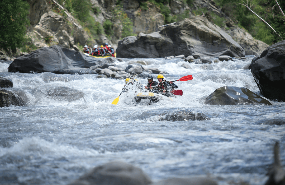 Grupo descendiendo por un río en balsa durante una actividad de rafting